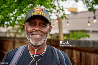Smiling veteran wearing a Marine Corps veteran hat